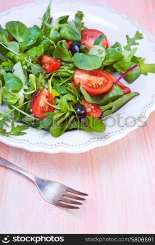 Pizza with dry cured ham and salad