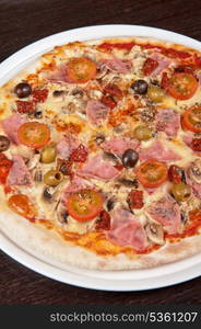 pizza with ham and mushrooms at the table