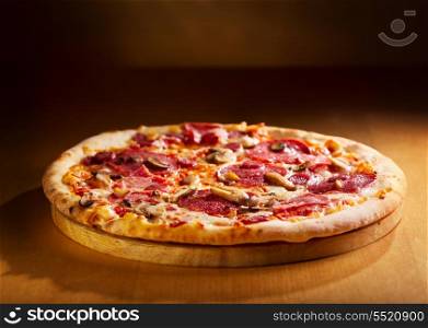 pizza with salami and bacon on wooden table