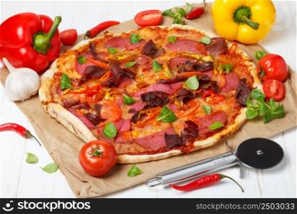 Pizza with salami and ham on wooden table