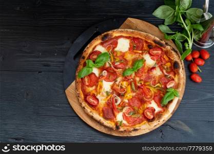Pizza with salami and tomatoes top view on wooden table. Pizza with salami and tomatoes