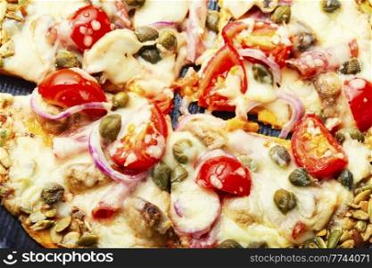Pizza with salami, cheese, tomato on a pumpkin crust. Homemade autumn recipe. Pizza on pumpkin flatbread