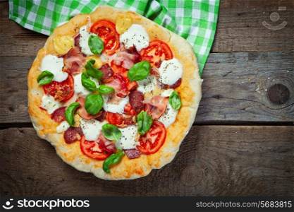 Pizza with salami, tomato and ham