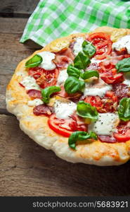 Pizza with salami, tomato and ham