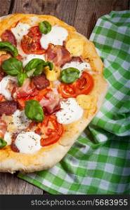 Pizza with salami, tomato and ham