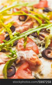 Pizza with salmon, tomatoes and olives. Close up view