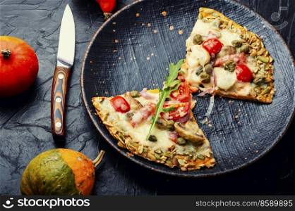 Pizza with sausage, tomato and capers on a pumpkin tortilla. Autumn pumpkin pizza