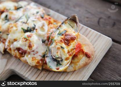 Pizza with seafood on wood background italian food