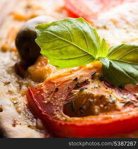 Pizza with tomatoes, olives and fresh basil, close up