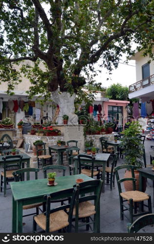 Place of restaurant with tables and chairs and an old oak.