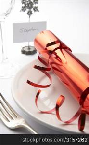 Place Setting With Christmas Cracker Against White Background