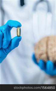Placebo Effect Concept. Female doctor holding model of brain and placebo supplement pill, explaining the placebo effect healing phenomenon. Placebo Effect Concept