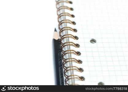 plaid notebook with a spiral and pencil
