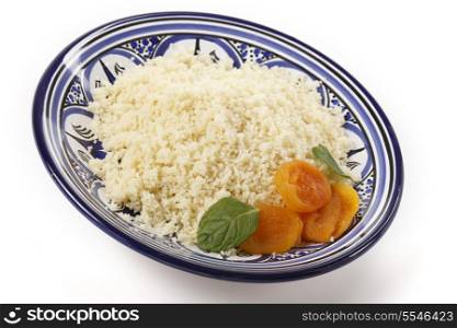 Plain couscous on a Tunisian handmade and hand-painted plate garnished with dried apricots and mint leaves