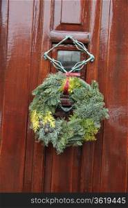 Plain green christmas wreath on a classic wooden door