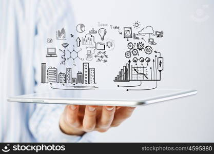 Plan for electronic business. Hand of businessman holding tablet and business ideas sketches