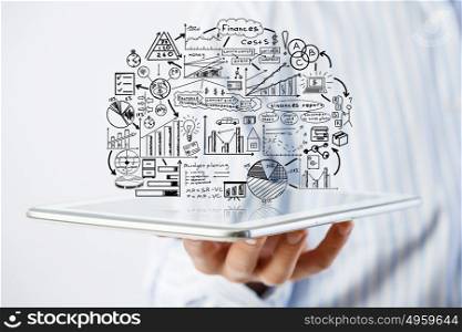 Plan for electronic business. Hand of businessman holding tablet and business ideas sketches
