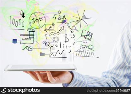 Plan for electronic business. Hand of businessman holding tablet and business ideas sketches