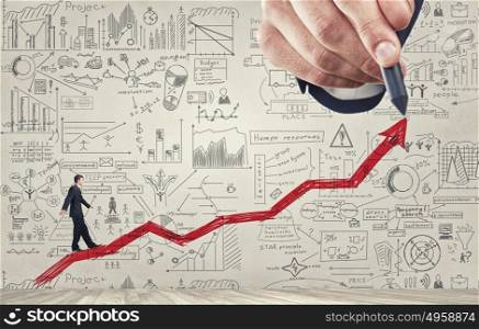 Plan for income rise. Businessman walking on rising graph arrow and sketches on background
