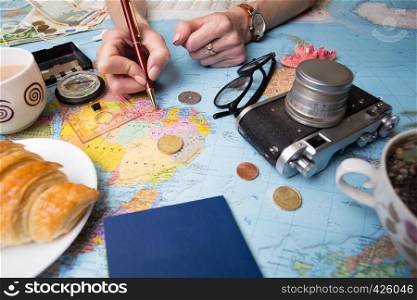 Plan of trip. background - what to take for a trip. Women's hands and map, retro camera, money, coins, croissant, coffee, pen, compass, sunglasses