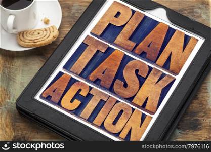 plan, task, action word abstract - text in vintage letterpress wood type on a digital tablet with a cup of coffee, management concept