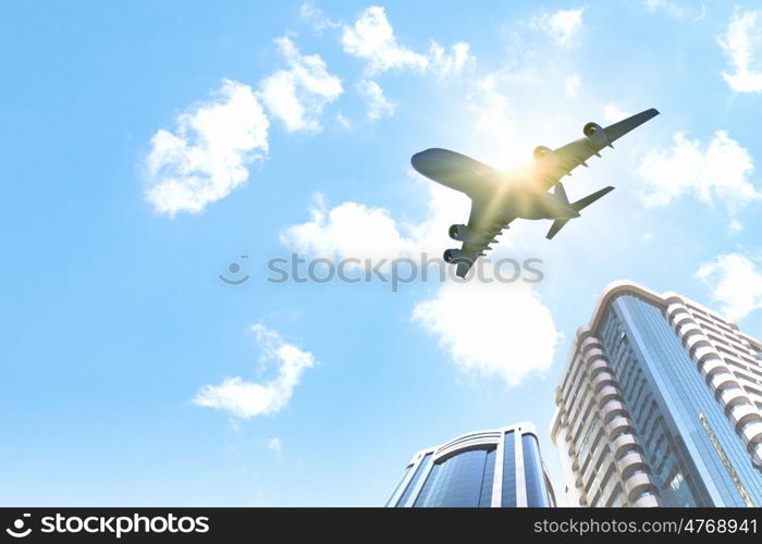 Plane in sky. Plane flying above skyscrapers. Business travel concept