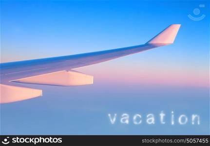 Plane in the air, wing of great luxury aeroplane on blue&pink sky background, business trip, travel and vacation concept