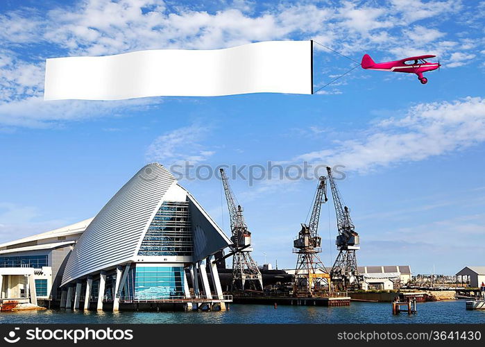 Plane in the sky above the city with blank flag