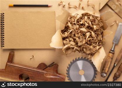 Plane jointer carpenter or joiner tool and wood shavings. Torn paper and woodworking tools at wooden table
