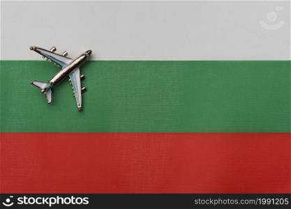 Plane over the flag of Bulgaria, the concept of travel. Toy plane on the flag as a background.. Plane over the flag of Bulgaria, the concept of travel.