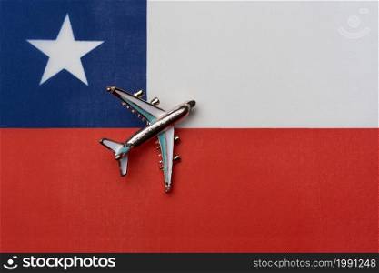 Plane over the flag of Chile, the concept of journey. Toy plane on the flag as a background.. Plane over the flag of Chile, the concept of journey.