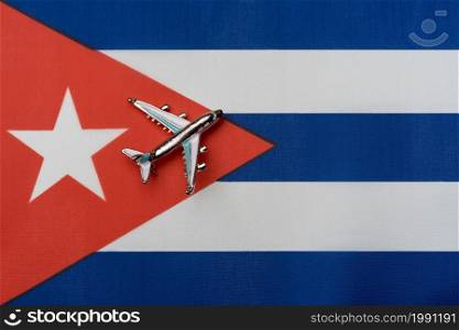 Plane over the flag of Cuba, the concept of travel. Toy plane on the flag as a background.. Plane over the flag of Cuba, the concept of travel.