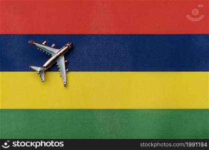 Plane over the flag of Mauritius, the concept of journey. Toy plane on the flag as a background.. Plane over the flag of Mauritius, the concept of journey.