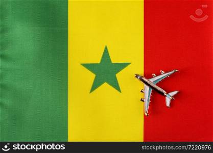 Plane over the flag of Senegal travel concept. Toy plane on a flag in the background.. Plane over the flag of Senegal travel concept.