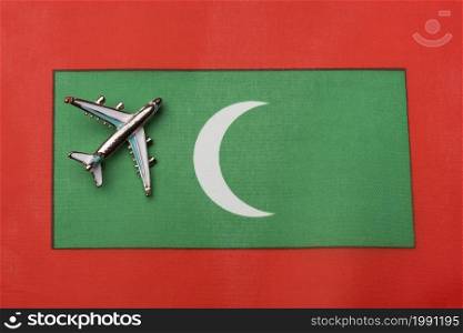 Plane over the flag of the Maldives travel concept. Toy plane on the flag as a background.. Plane over the flag of the Maldives travel concept.
