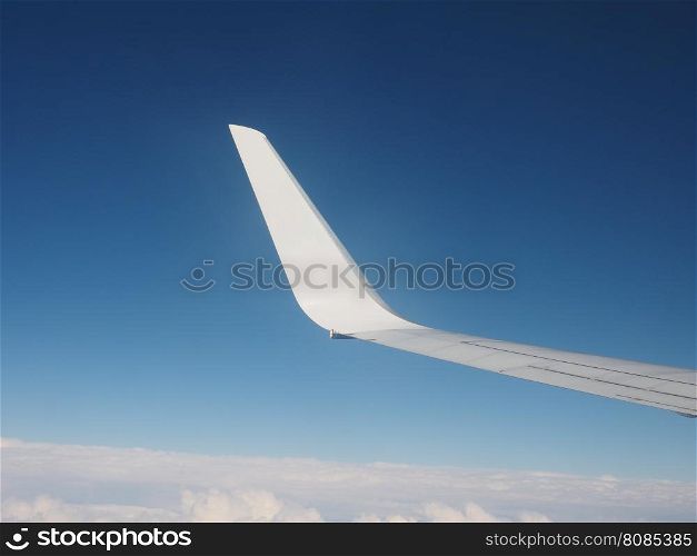 Plane wing detail. Airplane wing flying over the blue sky