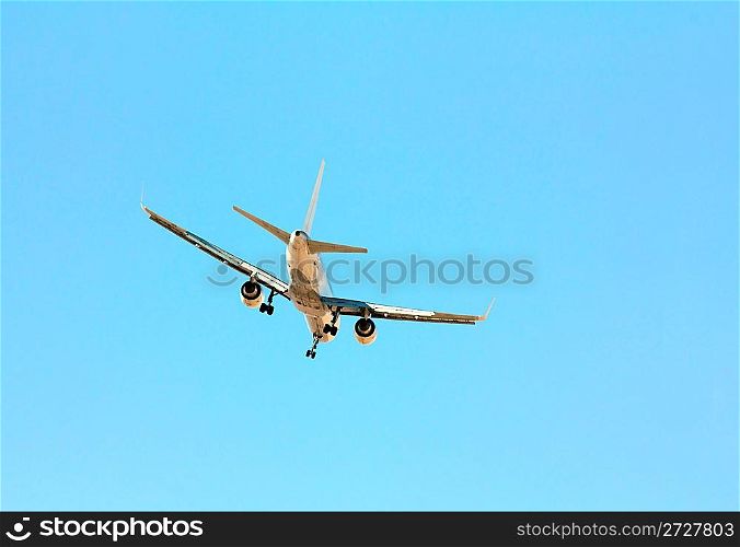 plane with landing gear comes in blue sky