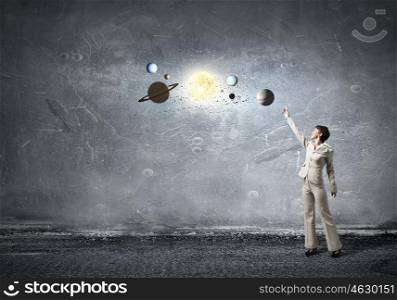 Planets of sun system. Young businesswoman reaching hand to space planets