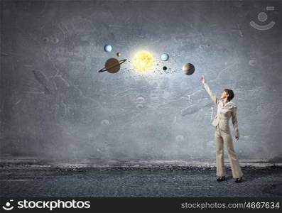 Planets of sun system. Young businesswoman reaching hand to space planets