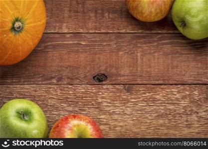 planks of rustic barn wood with pumpkin and apples, copy space