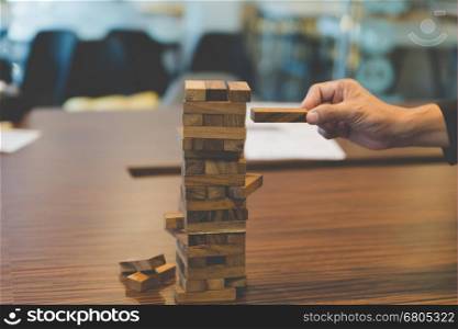 planning, risk and strategy in business, businessman gambling placing wooden block on a tower