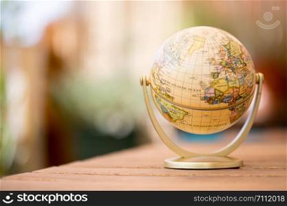 Planning the next journey: miniature globe on a rustic table