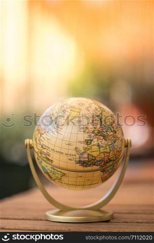 Planning the next journey: miniature globe on a rustic table