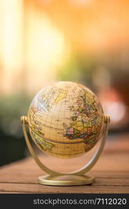 Planning the next journey: miniature globe on a rustic table