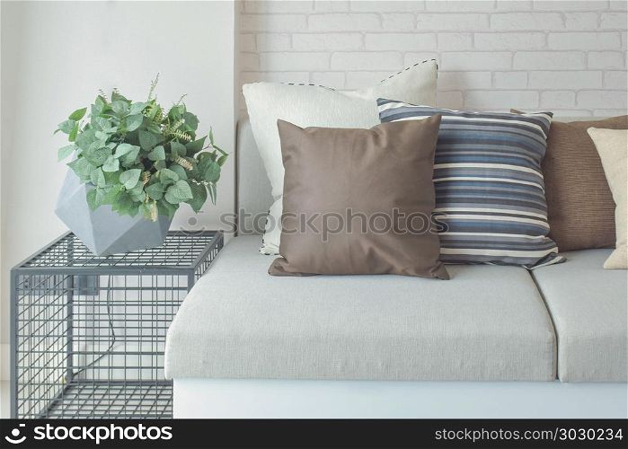 Plant pot on side table next to beige color sofa