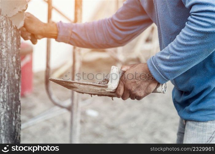 plasterer concrete worker at wall of home construction building