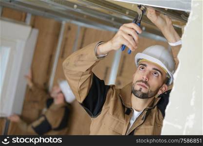 plasterer inspecting the ceiling frame