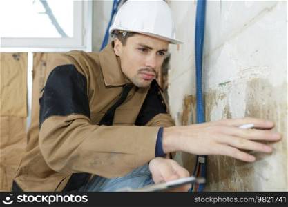 plasterer inspecting the wall
