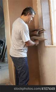 Plasterer Working On Interior Wall