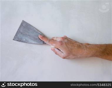 Plastering man hand with plaste and plaster spatula trowel in wall